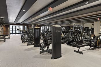 A gym with cardio machines and weights on the floor